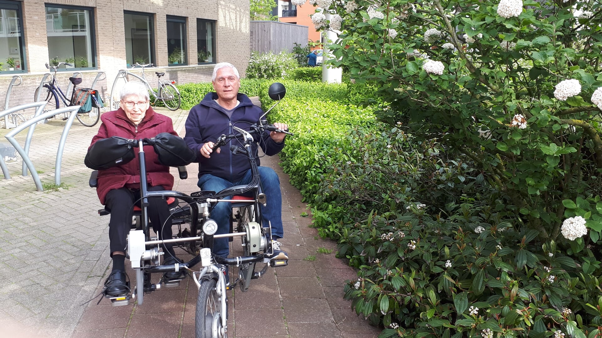 Dora van de Ven en Jan Coppelmans fietsen samen door Veghel.