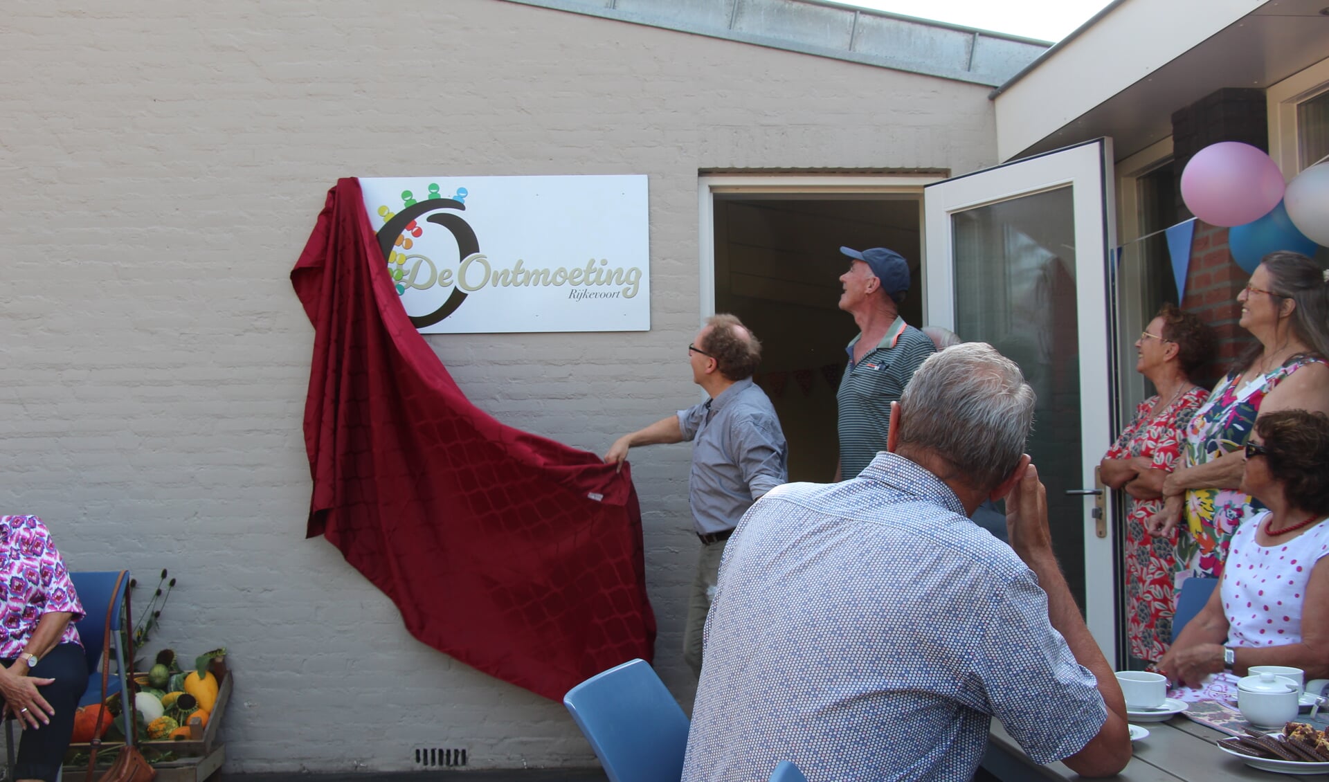 Max Kuijpers onthult het bord van De Ontmoeting. De ruimte is elke maandag van 09.30 tot 11.30 geopend voor iedereen.