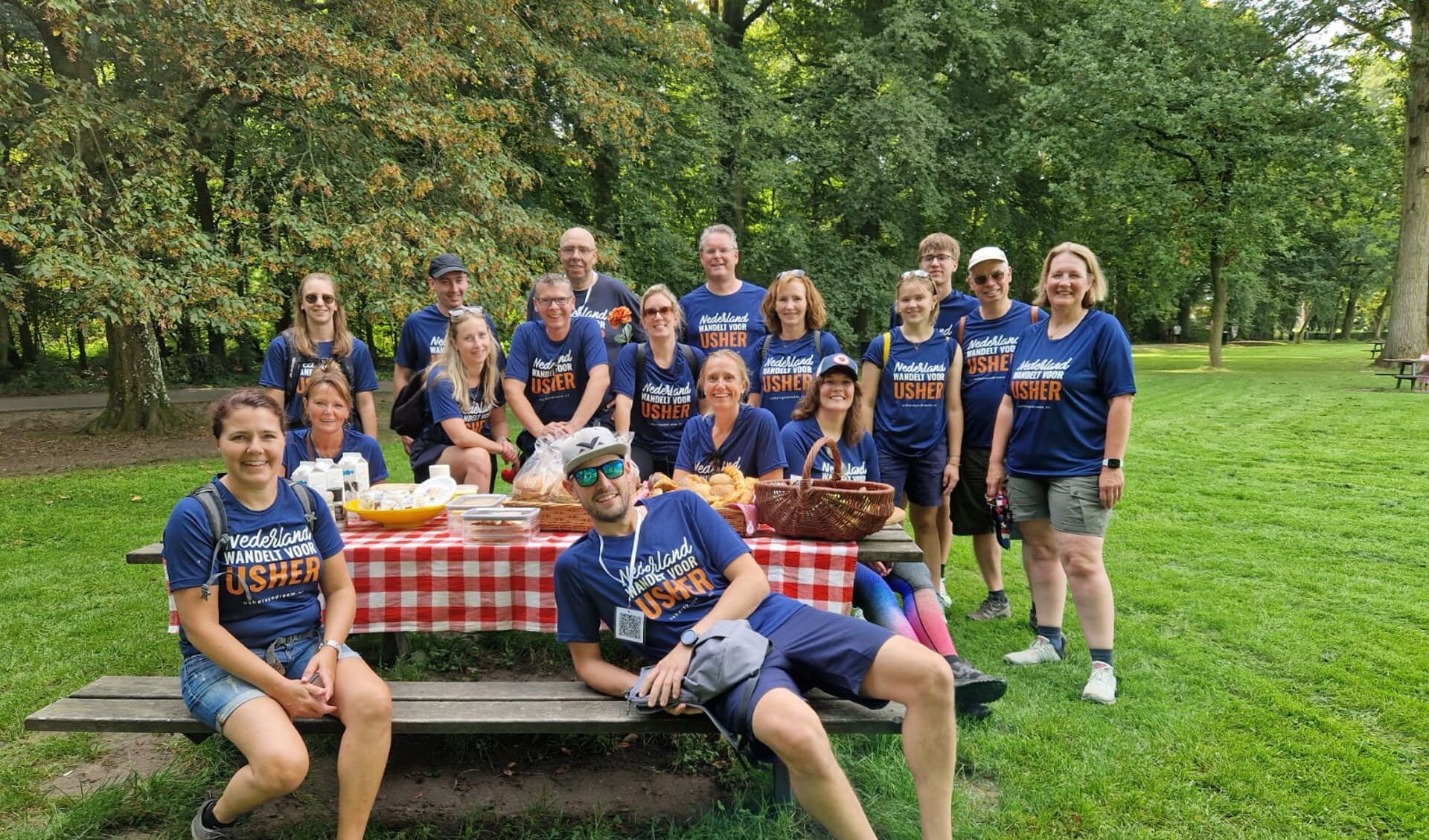 Team 'Carlyn' en team 'Geef om Usher' bij de picknick halverwege de wandeling.