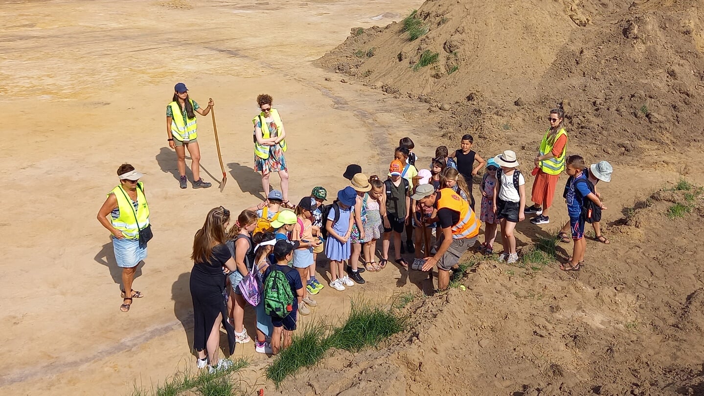 School op bezoek bij de Fieldschool in 2022. Studenten uit Leiden geven een rondleiding over het opgravingsterrein.