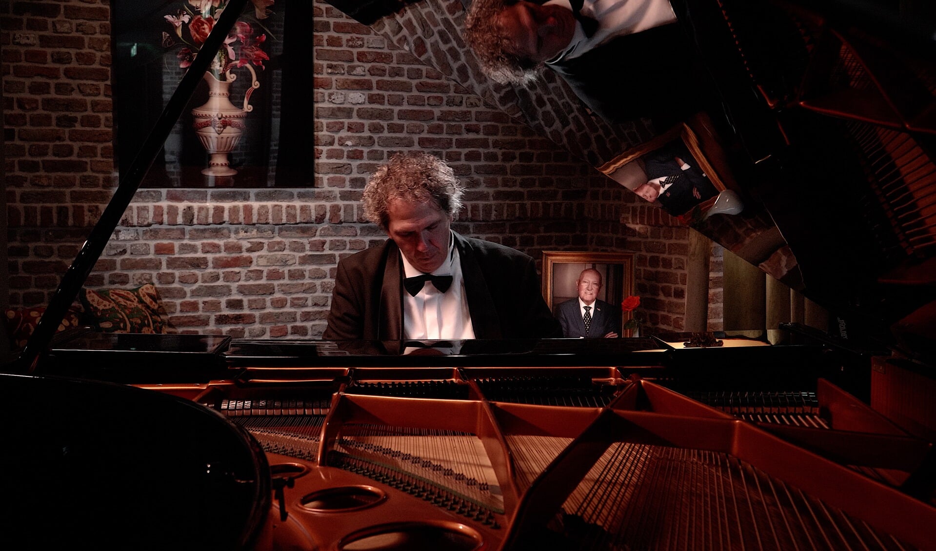 Dan Loredan tijdens het inspelen van het themanummer op de piano in The Duke. Op de achtergrond staat een portret van Karel van Eerd.