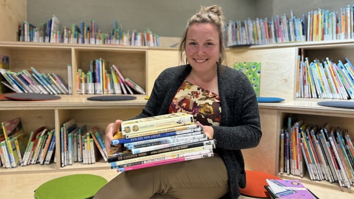 Judith Campman, met op schoot een paar kinderboeken, is de nieuwe coördinator VoorleesExpress Veghel.