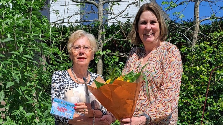 Elly van Liempt krijgt uit handen van Petra Huibers een bloemetje.