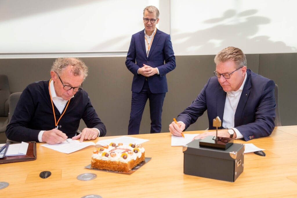 George Jentjens en Herman Molenaar tekenen de contracten, Vermeulen kijkt toe.