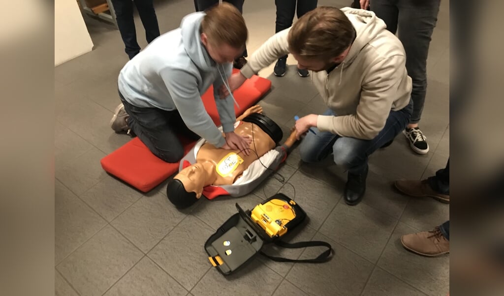 Twee deelnemers oefenen met de AED