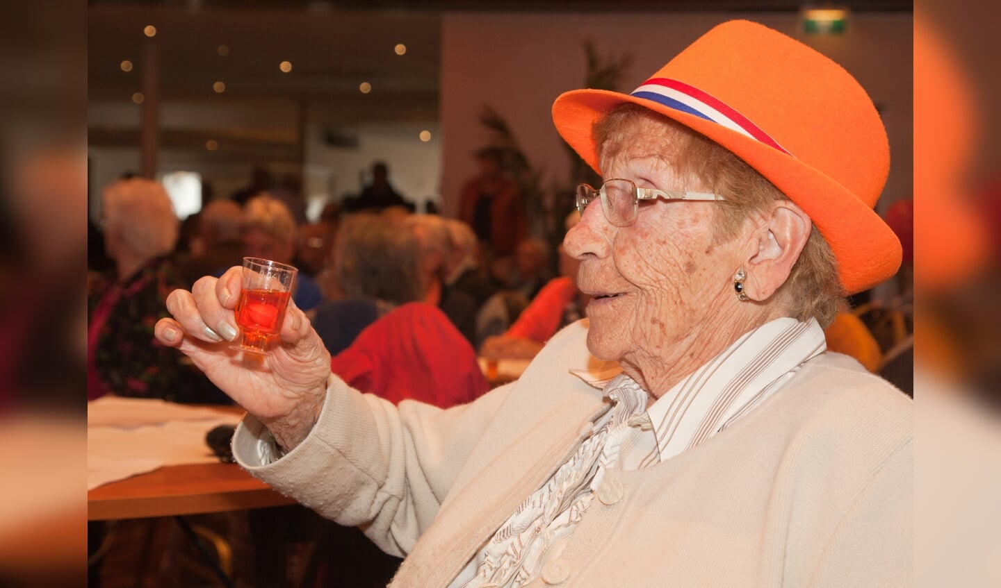 Een toost op de Koning; de 97-jarige mevrouw Gerts liet het oranjebittertje zich goed smaken