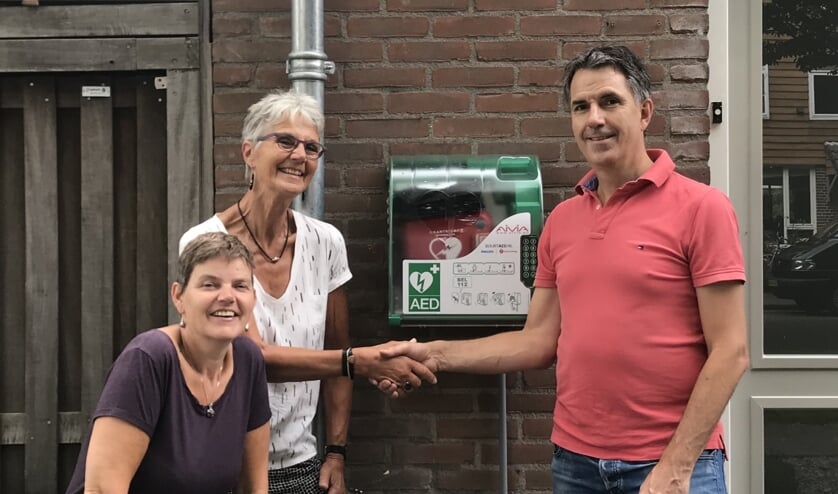 Bij de AED v.l.n.r. buurtbewoners Ria van Dijk en Hetty Veerman, en Erik Jan Boon van Lions Bodegraven