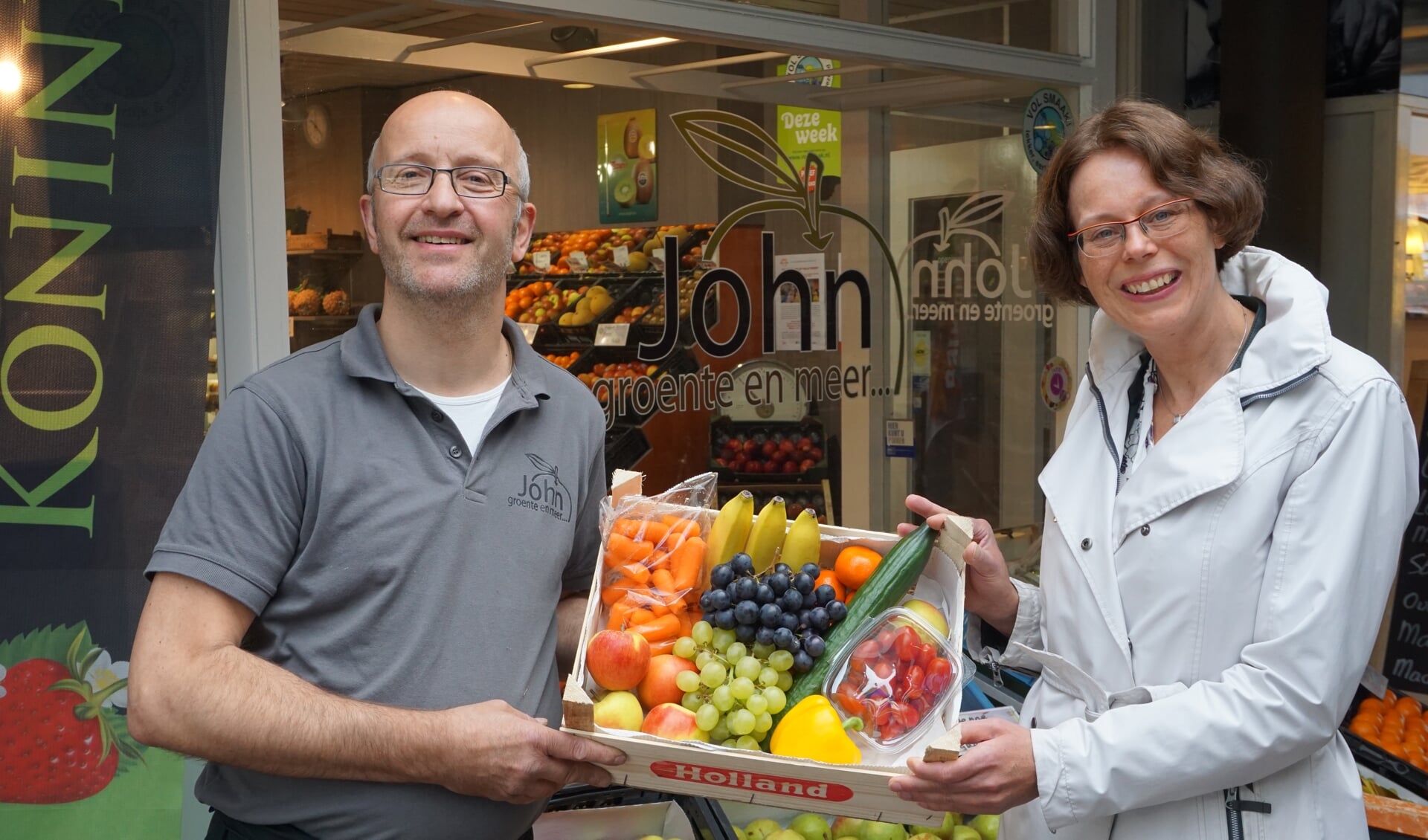Groenteman John van Dijk en OKÉ-klas coördinator Agnes van der Kraan met het eerste groente- en fruitpakket