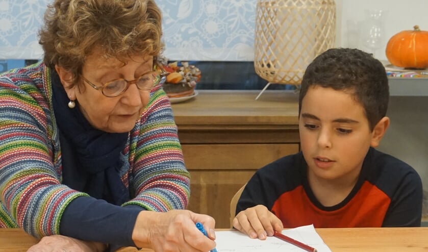 <p>Vrijwilliger Charmian helpt met het huiswerk in de OKÉ-klas van Bureau Bousa.</p>