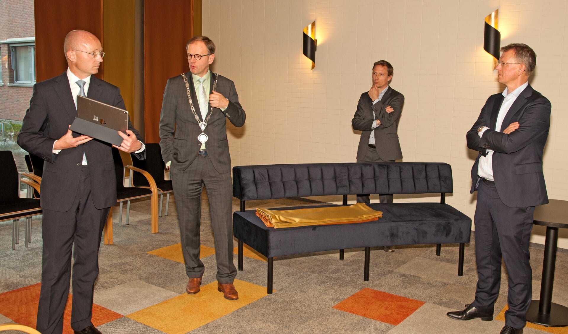 Raadsgriffier Hans Rijs geeft uitleg over het digitale vergadersysteem aan de heren Bagchus (rechts) en Steur.