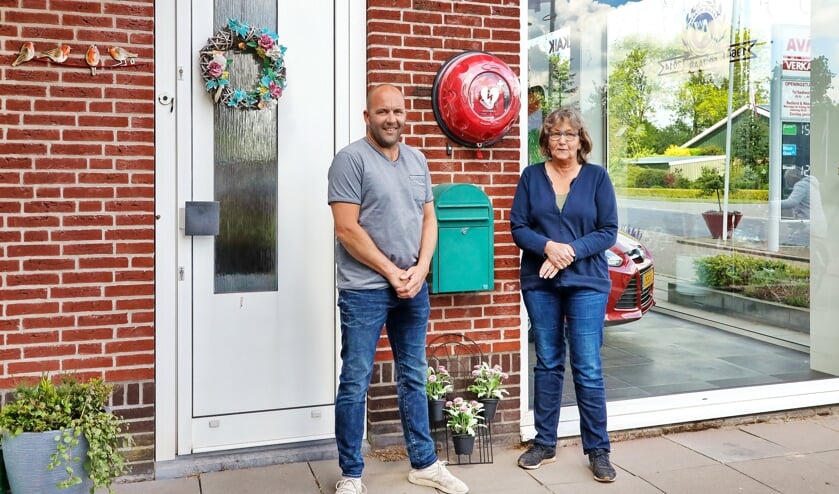 Johan van Eijk van Ons Fonds Wierickeland en Hanny Pastoor van de EHBO-vereniging bij de nieuwe AED aan de gevel van de Fa. Verkaik