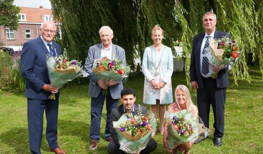 de gedecoreerden met vlnr. Piet van Velzen, Cor van Dam, locoburgemeester Inge Nieuwenhuizen en Leo Wolswijk, geknield: Driss Bakkali en Angenieta Kaatee