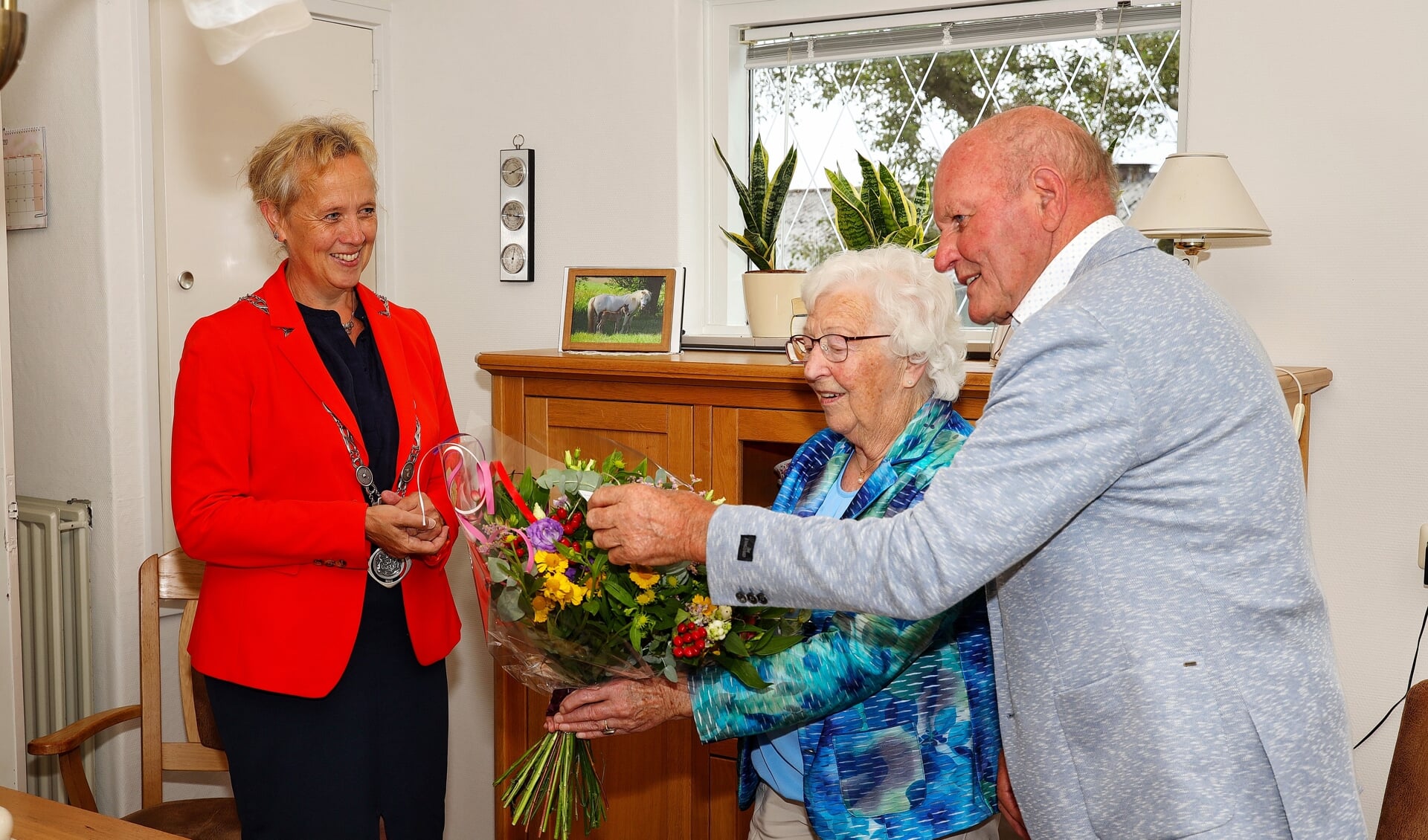 Het stel ontvangt bloemen van loco-burgemeester Nieuwenhuizen.