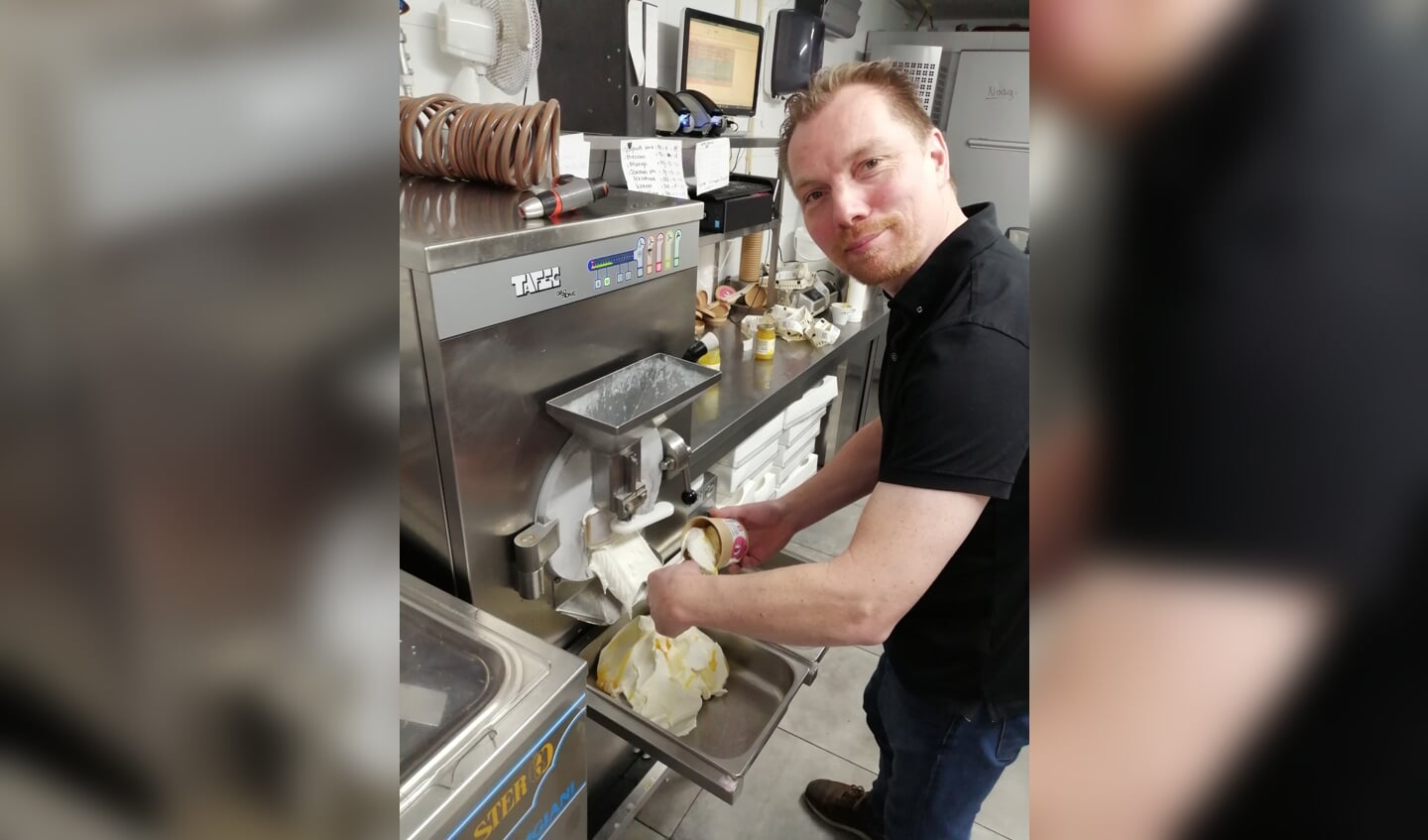 Jurgen schept het ijs vers uit de ijsmachine in de verpakking.