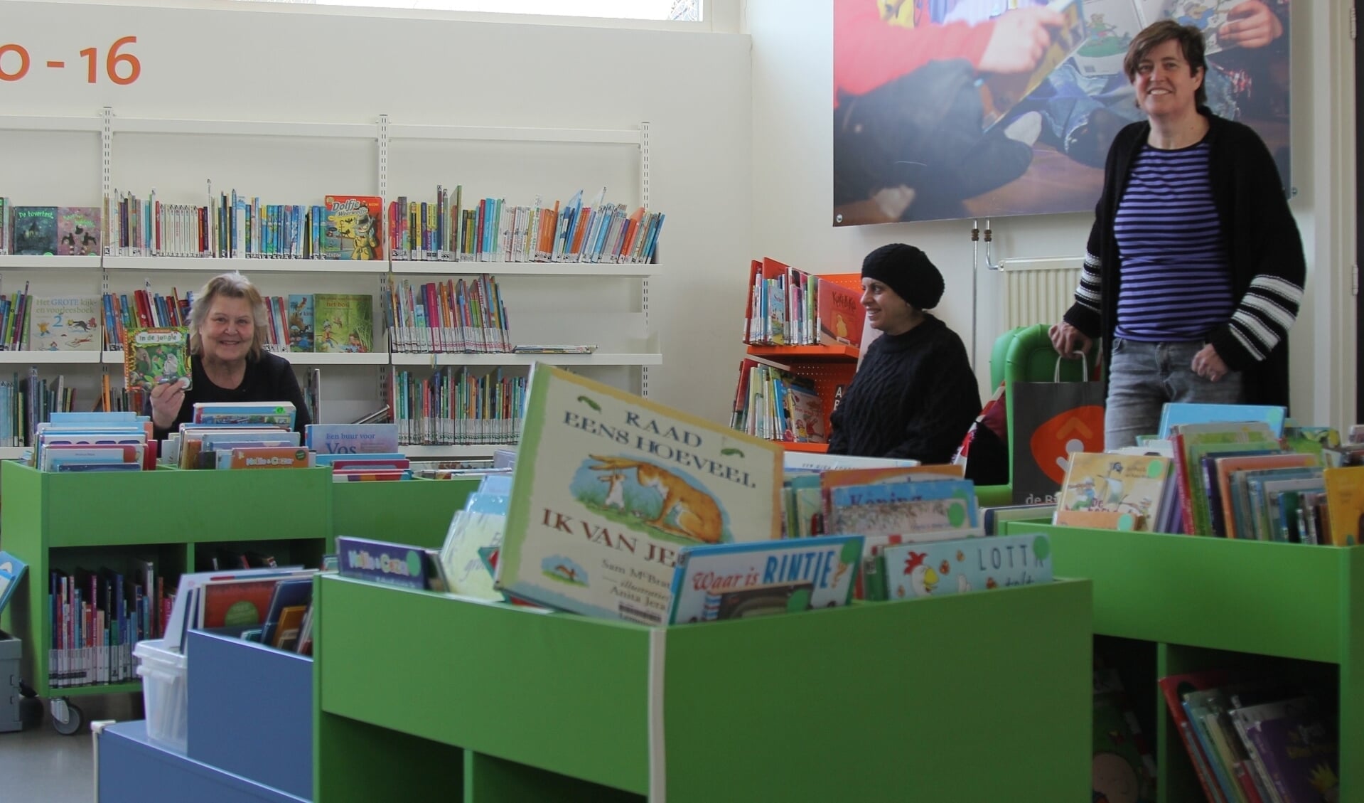 Marguerite Steenwijk, Abiir Almadani en teamleider Anne-Marieke Kromwijk tussen de kinderboeken in de Reeuwijkse vestiging. 