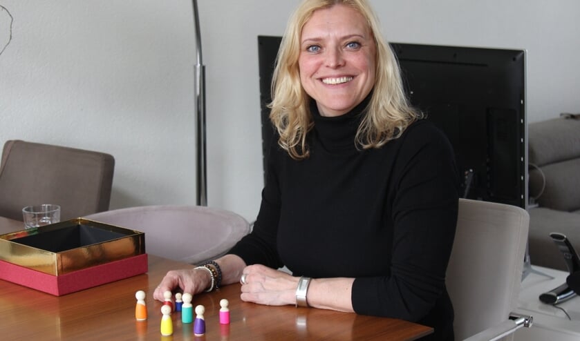 <p>Helma Horsmans en haar houten poppetjes. Elk popje staat voor een van de familieleden.</p>