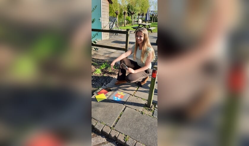 <p>Aletta Moonen bij haar mozaïektegel met het gemeentewapen van Reeuwijk.</p>
