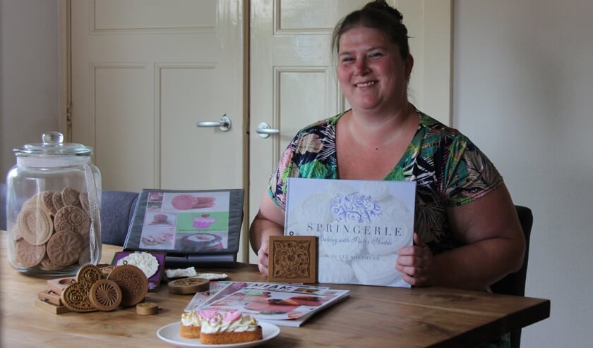 <p>Marlies, met in haar handen het Amerikaanse boek dat vol van haar creaties staat.</p>