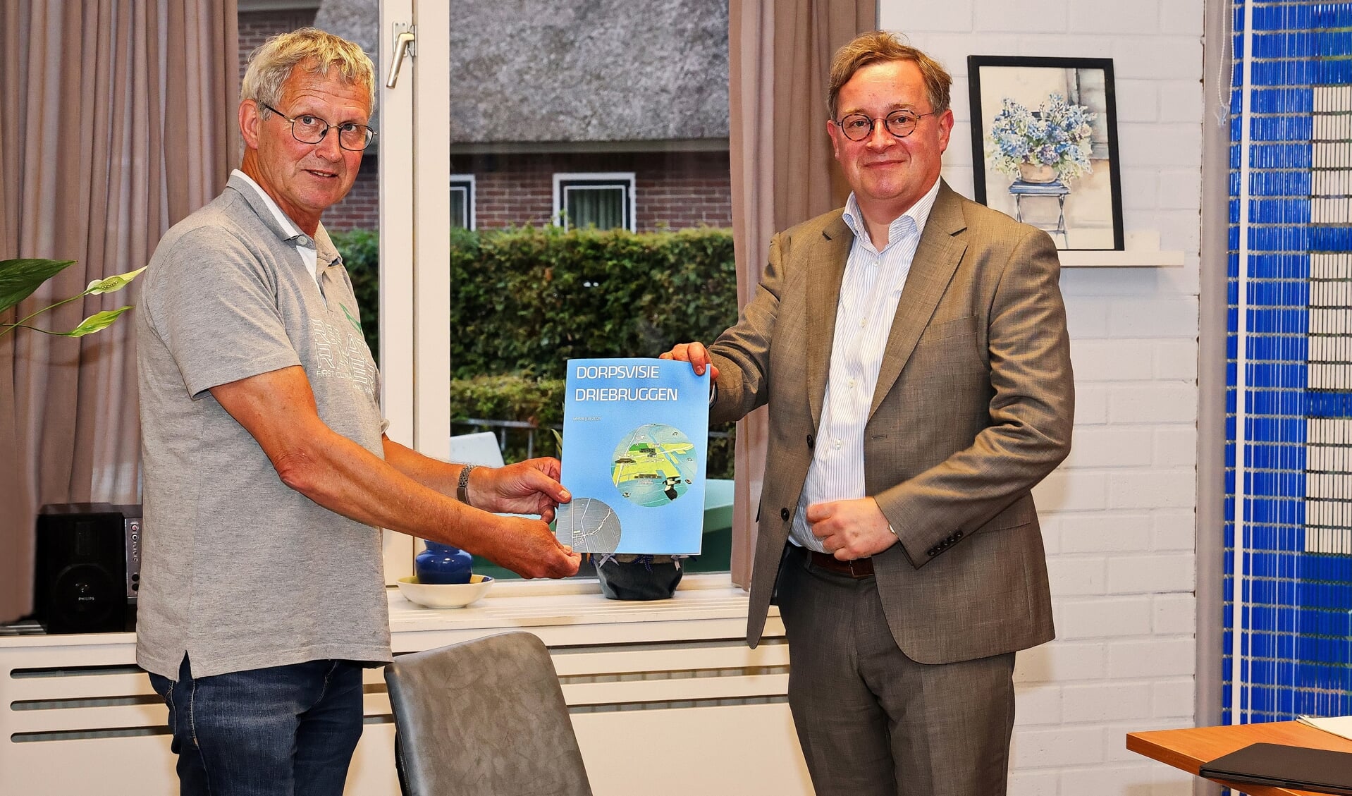 Joop van den Nouland overhandigt de dorpsvisie aan wethouder Jan Leendert van den Heuvel.