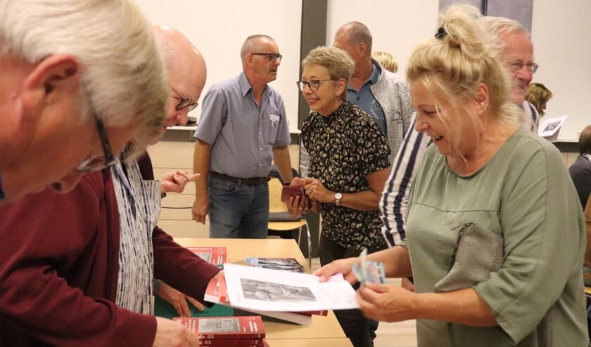 <p>In de pauze van de presentatie, toont de familie Kooistra zich reuze nieuwsgierig naar het boek. In het midden schrijver Ruud Kooistra.</p>