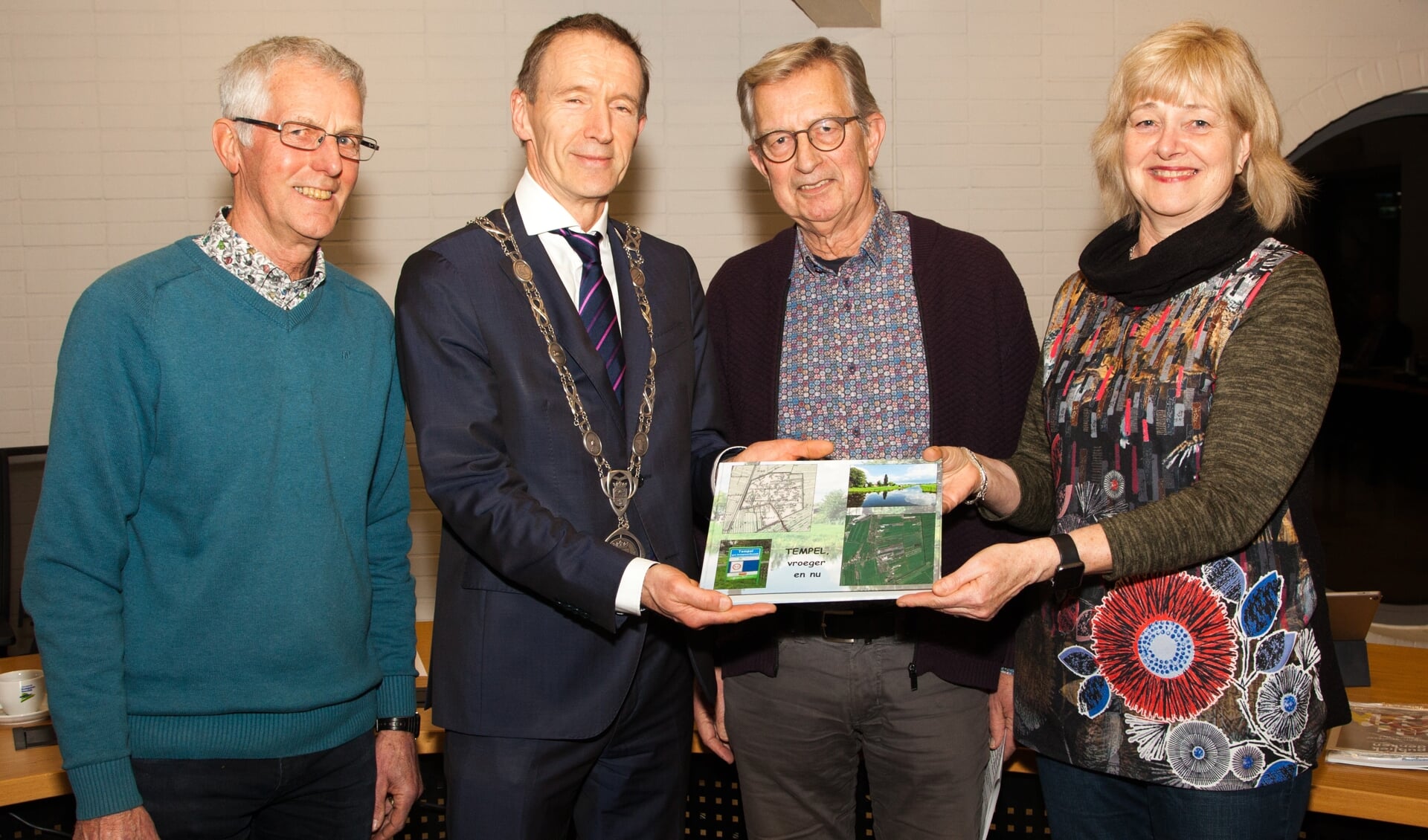 Mieke Egels, Wim Kuijf en Kees Vermeulen bieden het boek 'Tempel vroeger en nu' aan aan burgemeester Erik van Heijningen. Angela Mathot ontbreekt op de foto.