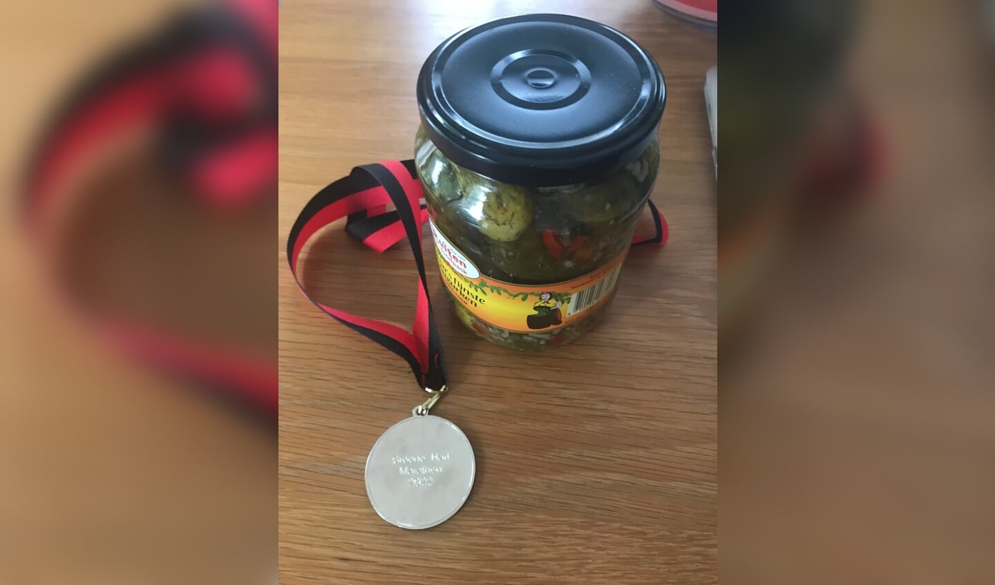 Een medaille en een pot augurken als 'prijs'. 