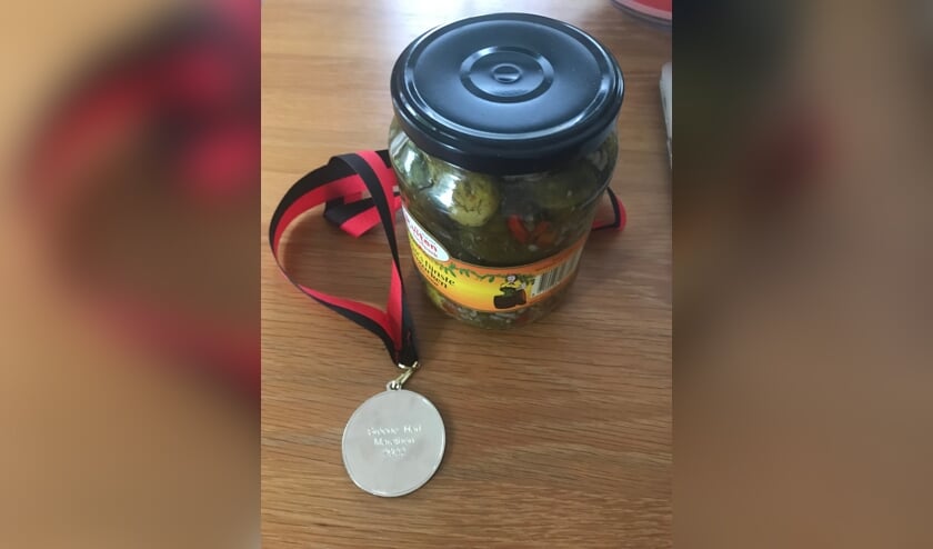 Een medaille en een pot augurken als 'prijs'.