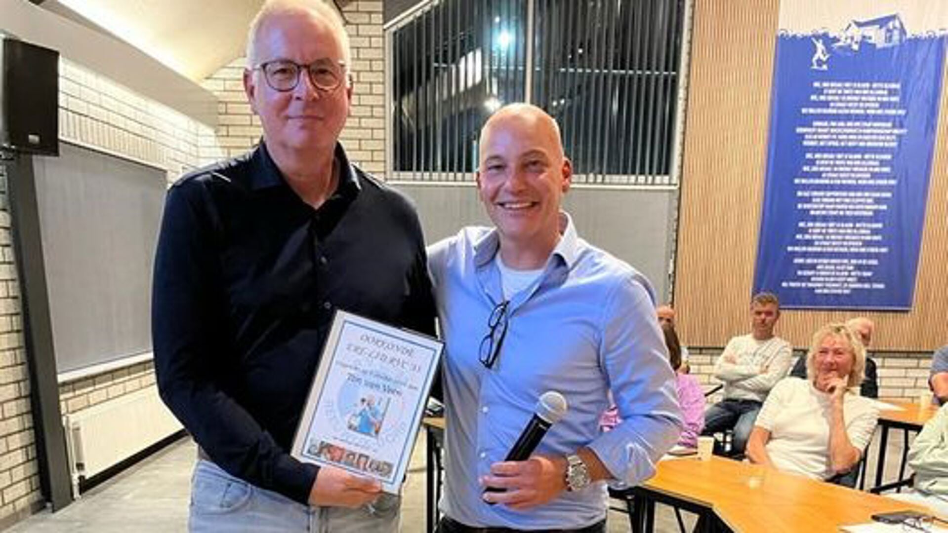 Penningmeester Arthur van Dongen (rechts) overhandigt Ton van Veen namens het bestuur de oorkonde.