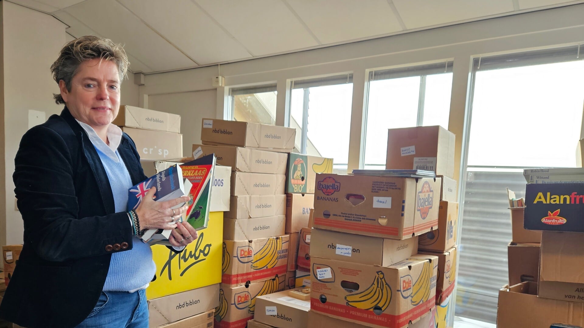 Directeur van het Evertshuis Jackie van der Vlis bij de ingeleverde boeken.