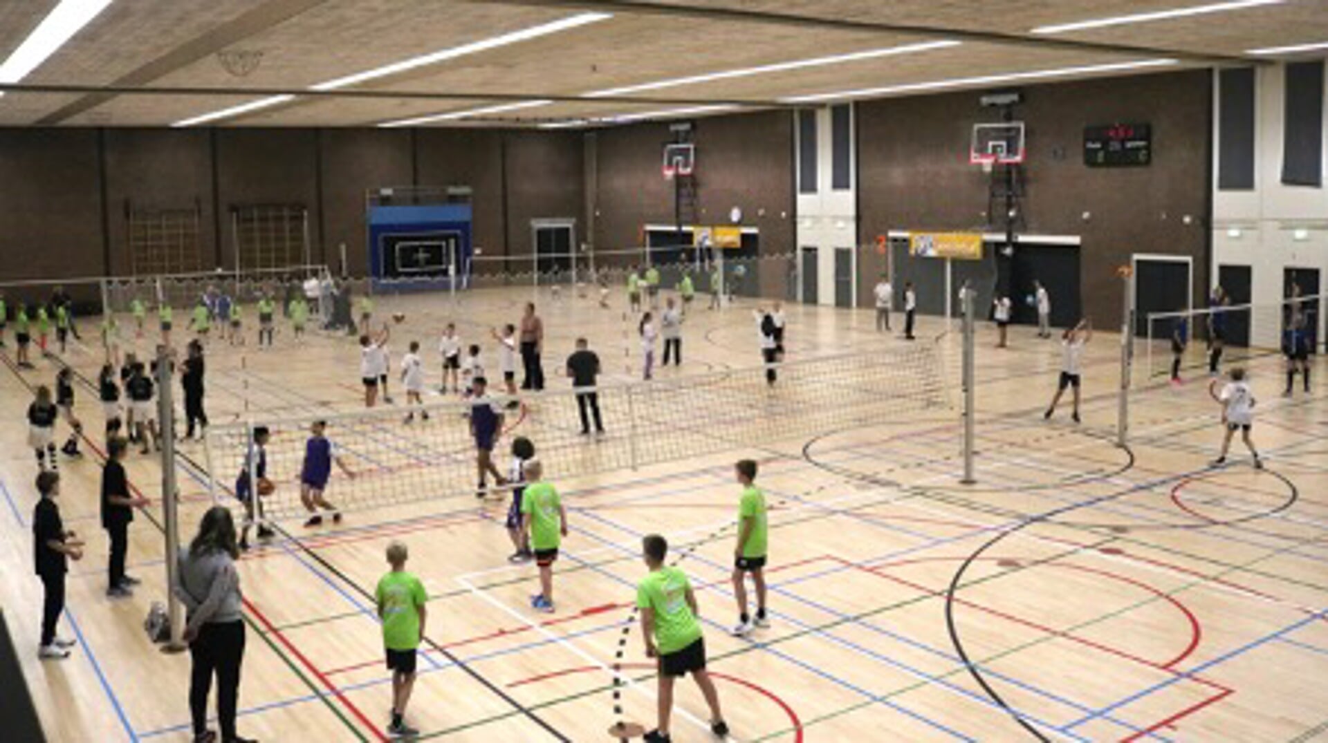 Volle sporthal bij volleybaltoernooi voor basisscholen.