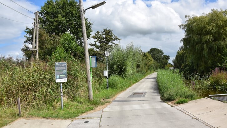 Tussen Lecksdijk 6 en 8 liggen betonplaten op het stuk weg dat is gefundeerd met wilgentenen uit de omgeving. De meetapparatuur krijgt stroom van een zonnepaneel.