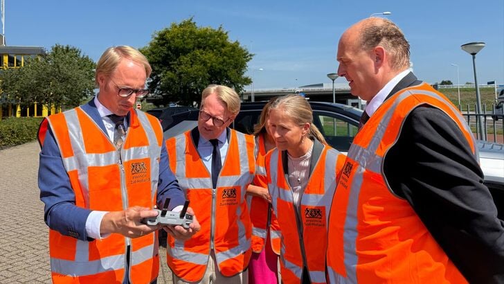 Wethouder Robin Kersbergen (links) laat minister Robert Tieman (tweede van links) en gedeputeerde Frank Zevenbergen (rechts) met een drone de verkeerssituatie zien bij de afslag van de N11.