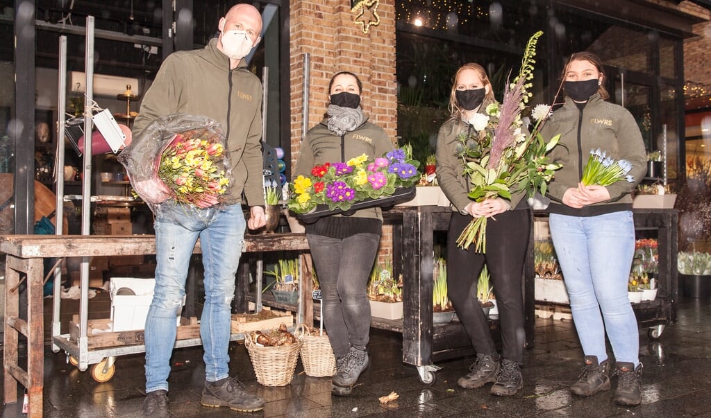  Ben de Vries (links) van bloemenzaak FLWRS is blij dat hij nog mag verkopen.