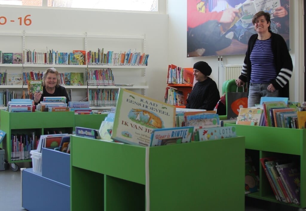 Marguerite Steenwijk, Abiir Almadani en teamleider Anne-Marieke Kromwijk tussen de kinderboeken in de Reeuwijkse vestiging. 