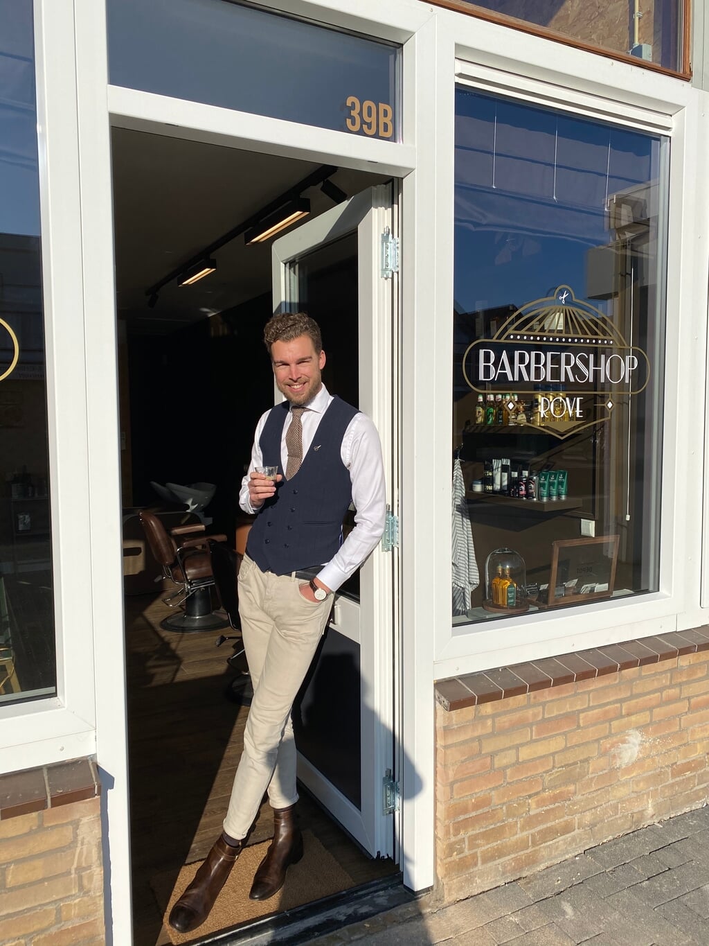 Eigenaar Rob Verwaal in de deuropening van zijn barbershop