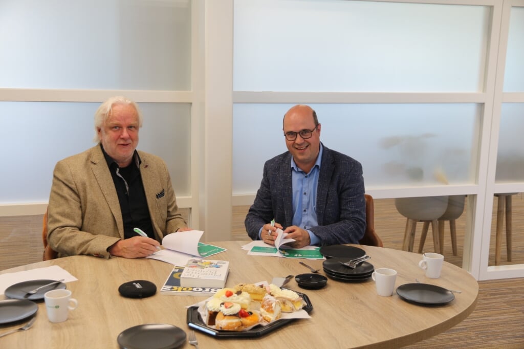 Harry Steenhuizen van Octobox (links) tekent de samenwerkingsovereenkomst met Bart Lageweg van Bizway (rechts).
