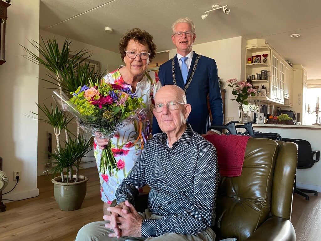 Aad en Tonny Vianen zijn door loco-burgemeester Dirk-Jan Knol verblijd met prachtige bloemen.