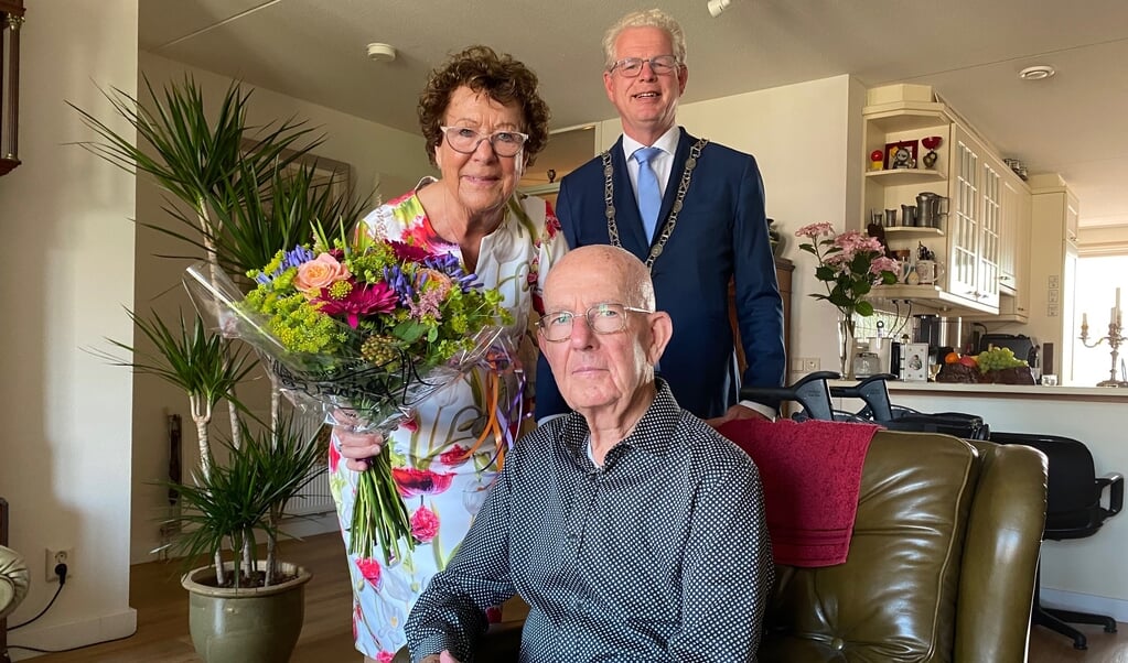 Aad en Tonny Vianen zijn door loco-burgemeester Dirk-Jan Knol verblijd met prachtige bloemen.