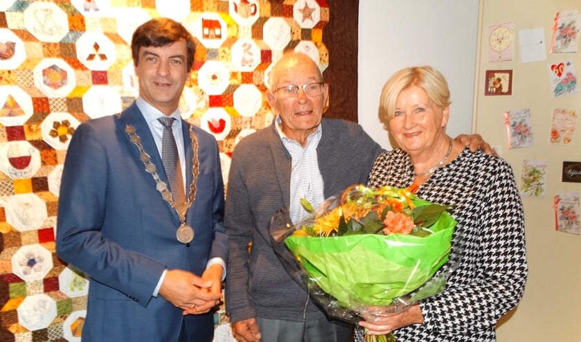 Hans en Riet poseren met de burgemeester voor een van Riets zelf gemaakte wandkleden. (Foto: AvdH)