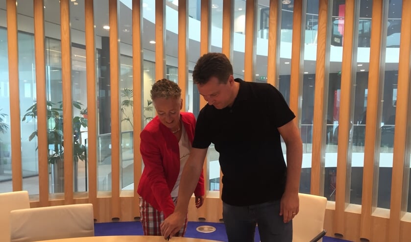 Wethouder Van Tatenhove en Leon Vijverberg snijden de taart aan.