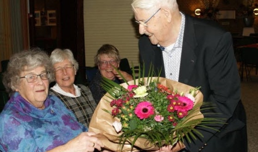 Jubilaris Veenman geeft de bloemen aan zijn vrouw. (Foto: PR)