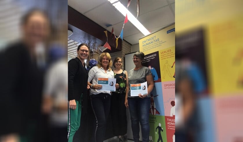De twee nieuwe vrijwilligers ontvangen een certificaat.