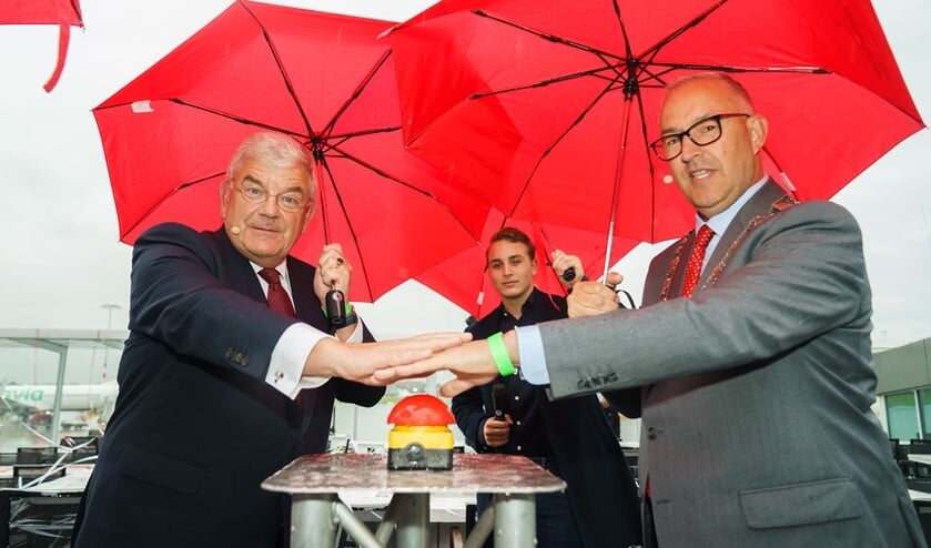 <p>Op een regenachtig vliegveld verzorgden de burgemeesters van Rotterdam en Den Haag de officiële opening van de nieuwe vertrekhal. (Foto: Koen Laureij) </p>