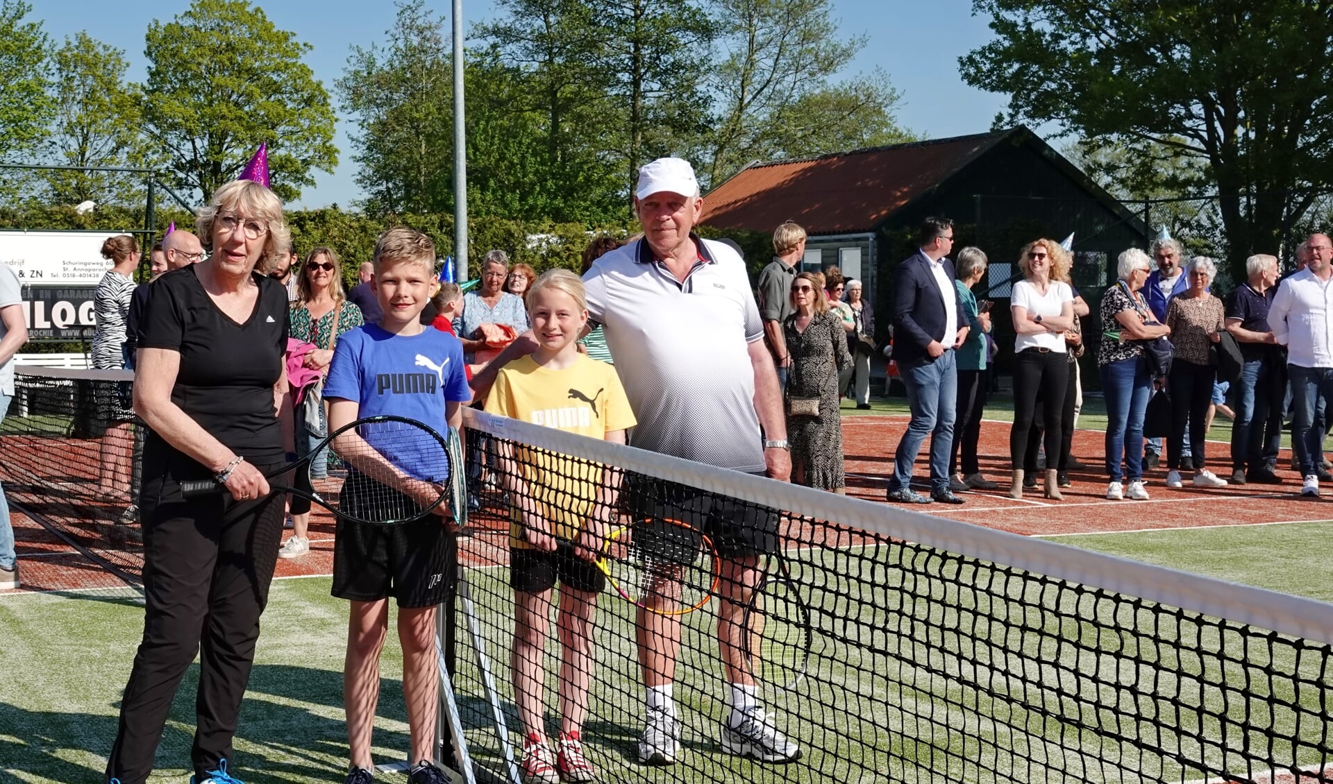 Onder toeziend oog van hun supportersschare staan Klaske Miedema, Reinder van der Meij, Elle Rins van der Meij en Klaas van der Meer klaar om de baan open te tennissen.