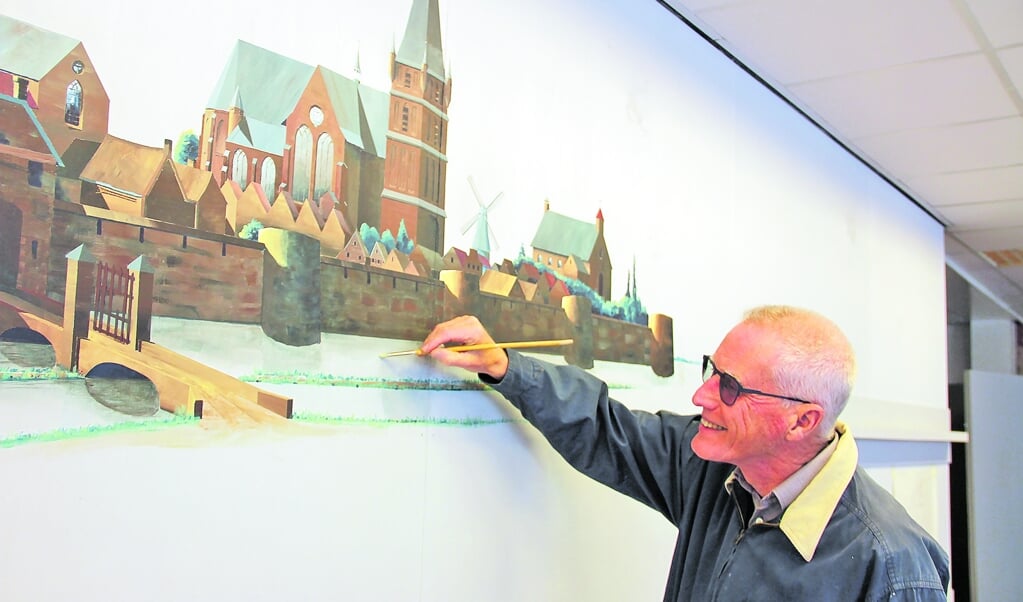 Lex van Wijk legt de laatste hand aan de wandschildering.