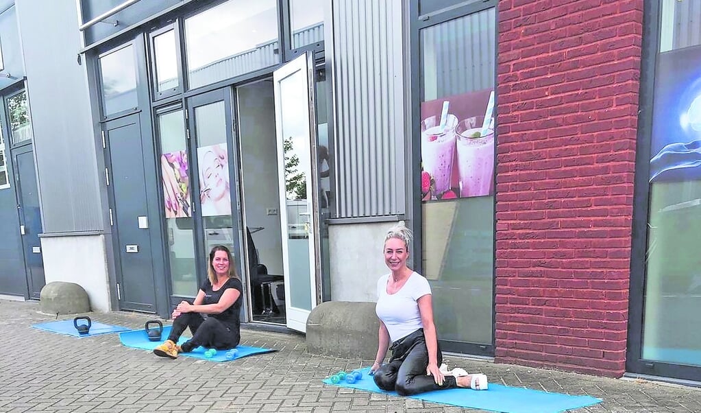 Eigenaressen Sandra en Lotte van Beautyplaza laten zien hoe het buitensporten bij ShapePlaza nu in zijn werk gaat. Gewoon buiten op een matje op de grond.