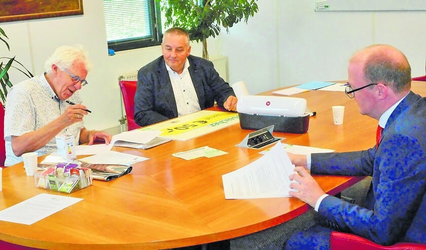 <p pstyle="BODY"><br>Wethouder Bas Lont en toezichthouder Henk Brouwer van energieoudewater.nl ondertekenen de overeenkomst waarbij de coöperatie de beschikking krijgt over het te besteden bedrag. Brouwer heeft een rolletje folie en een led-lamp meegebracht. Bestuurslid Fred van Schaik moet ook nog tekenen.</p>