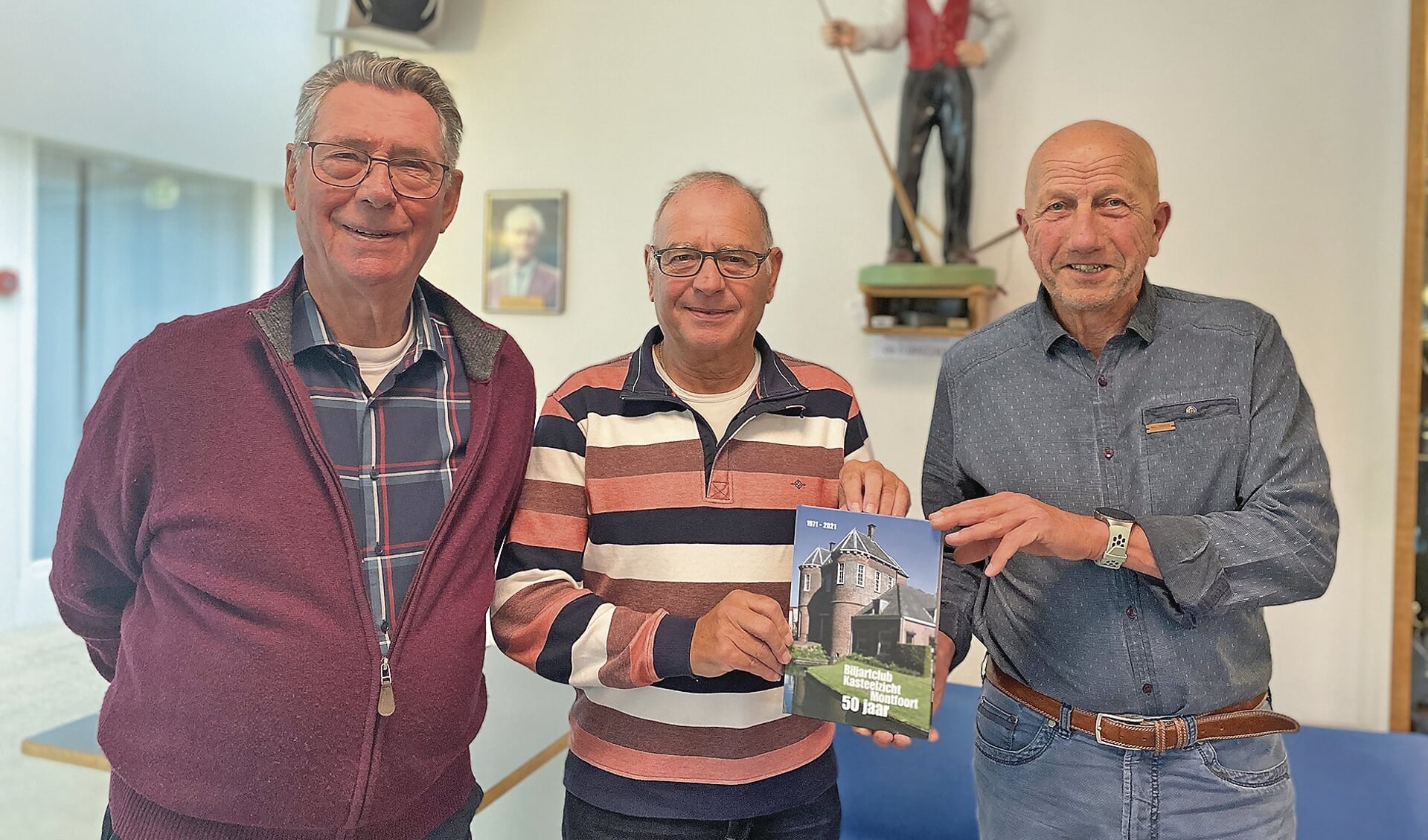 Cees Vlooswijk, Paul den Houdijker en voorzitter Jan van Leeuwen met het jubileumboek.