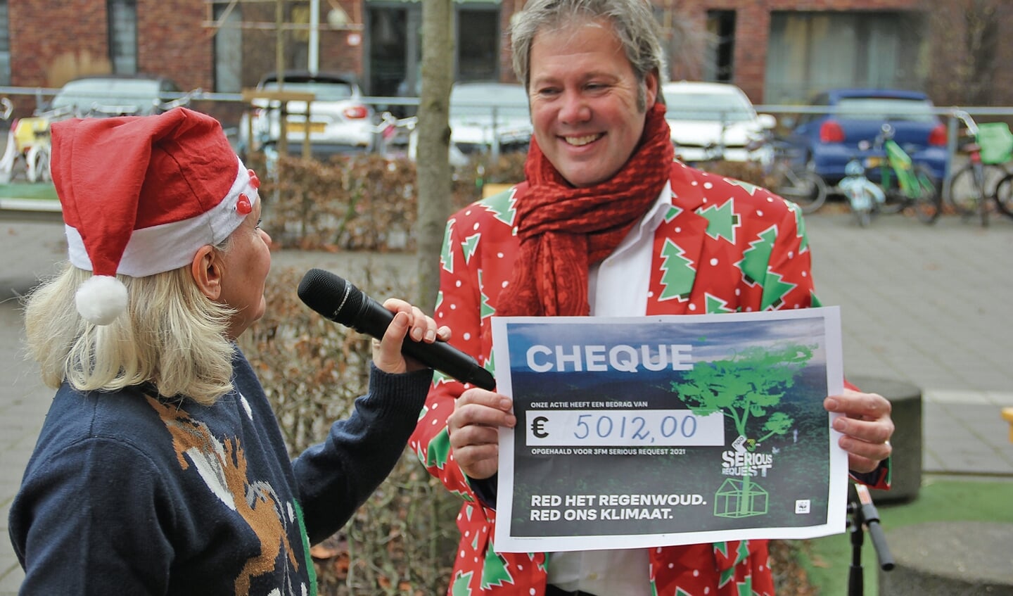 Burgemeester Danny de Vries in zijn 'foute kerstjasje' mocht de totaalopbrengst onthullen met een cheque.