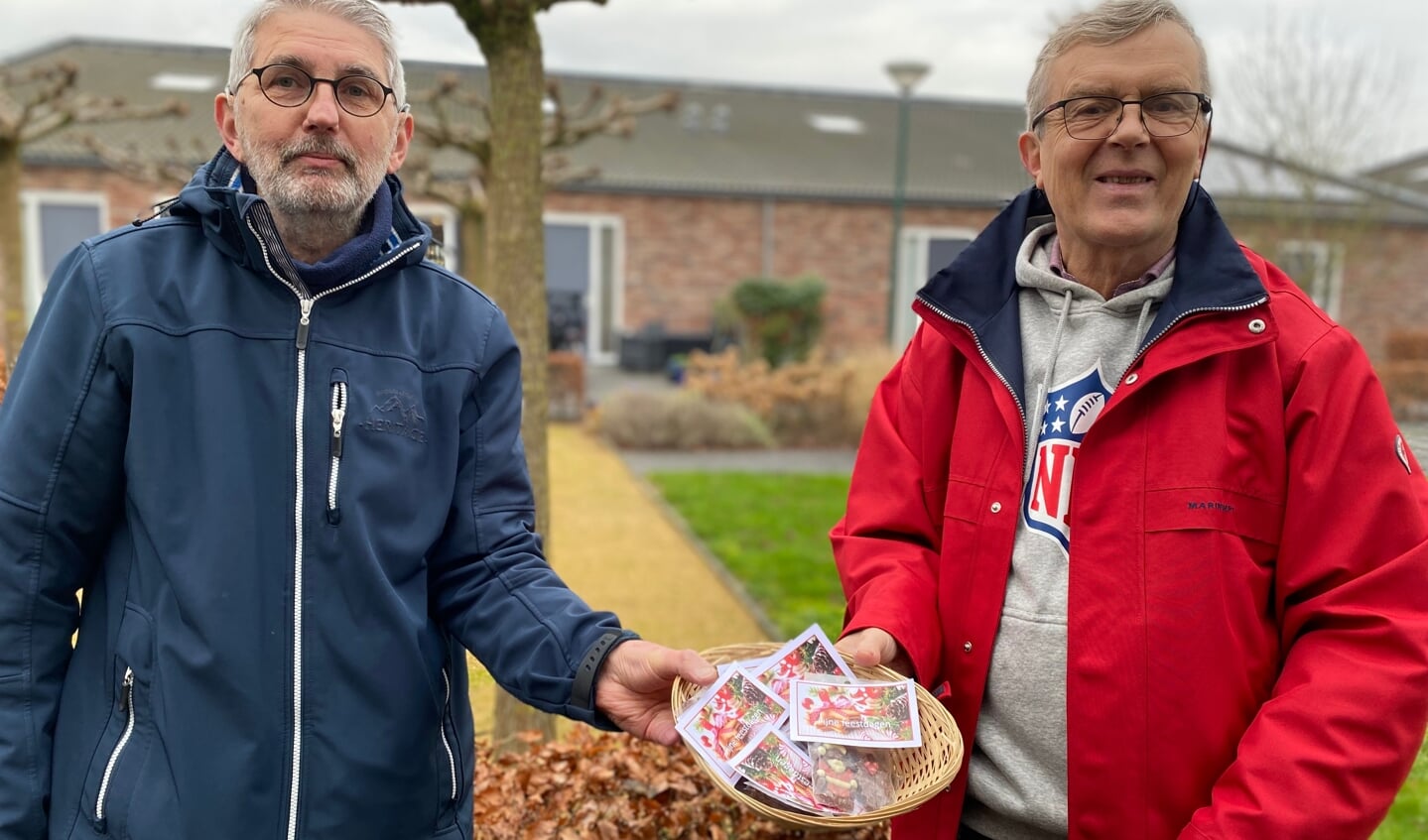 Jan-Maarten Verbeek en Ton Bunnik brengen als bestuursleden van de Vrienden van SWOM kerstchocolaatjes rond.
